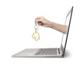 Hand holding house key comes from laptop screen Royalty Free Stock Photo