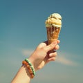 Hand holding ice cream cone on the sky background Royalty Free Stock Photo