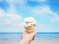 Hand holding ice cream over summer beach background Royalty Free Stock Photo