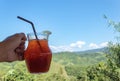 Hand holding Iced black coffee in a glass jar and view mountain Royalty Free Stock Photo