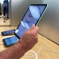 A hand holding a 10.9 inch iPad Air tablet computer at an Apple store Royalty Free Stock Photo