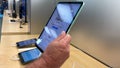 A hand holding a 10.9 inch iPad Air tablet computer at an Apple store Royalty Free Stock Photo