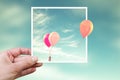 Hand holding an instant photo with air balloons, think outside the box concept Royalty Free Stock Photo