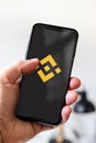 Hand holding iphone smartphone with Binance crypto currency logo, Paris, France