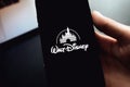 Hand holding the iPhone X with Disney logo on the screen.