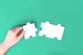 Hand holding a jigsaw puzzle piece on green Royalty Free Stock Photo