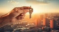 Hand holding a key against backdrop of the city. Concept of new apartment, real estate purchase, home buying, and