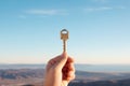 Hand holding key on sky background . AI Generated Royalty Free Stock Photo