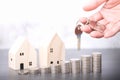 Hand holding a key and Wooden house model with coins or real estate concept. Real estate broker. insurance Royalty Free Stock Photo