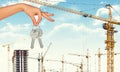 Hand holding keys on construction site background Royalty Free Stock Photo