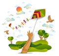 Hand holding kite over cloudy sky birds flying and sun, meadows and trees scenic nature landscape, freedom and easiness emotional Royalty Free Stock Photo