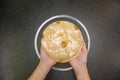 Hand holding kombucha scoby tea mushroom against stone background with bowl