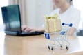 Hand holding Laptop with small shopping cart Royalty Free Stock Photo