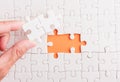 Hand-holding last piece white paper jigsaw puzzle game last pieces put to place Royalty Free Stock Photo