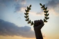 Hand Holding Laurel Wreath Sunset Sky