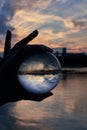 Hand holding lensball in front of beautiful sunset