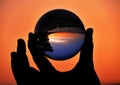 Hand holding lensball at sunset