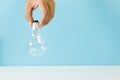 Hand holding Light bulb blue background. symbol of creativity. Royalty Free Stock Photo