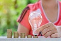 Light bulb with Coins stack on wooden table in the morning. Energy and Money saving , accounting and financial concept Royalty Free Stock Photo