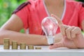 Light bulb with Coins stack on wooden table in the morning. Energy and Money saving , accounting and financial concept Royalty Free Stock Photo