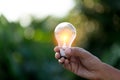 Hand holding light bulb,energy sources for renewable,natural energy concept Royalty Free Stock Photo