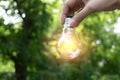 Hand holding light bulb in garden green nature background. Royalty Free Stock Photo