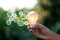 Hand holding light bulb with icons energy sources for renewable,love the world concept Royalty Free Stock Photo