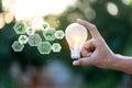 Hand holding light bulb with icons energy sources for renewable,love the world concept Royalty Free Stock Photo