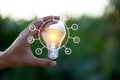 Hand holding light bulb with icons energy sources for renewable,love the world concept Royalty Free Stock Photo