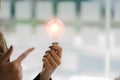 Hand holding a light bulb. Innovative and inspirational concepts looking for new ideas for designing, working better with innovati