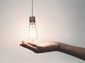 Hand holding a light bulb, in isolated background, AI generated Royalty Free Stock Photo