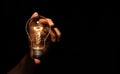 Hand holding light bulb isolated on black background.Energy or idea concept Royalty Free Stock Photo