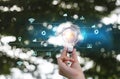 Hand holding light bulb nature background with energy power icons. Energy power electric environment from nature concept Royalty Free Stock Photo