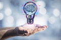 Hand holding light bulb sketch on blurry bokeh background. Royalty Free Stock Photo