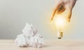 Hand holding light bulb on wooden desk Royalty Free Stock Photo