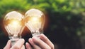 Hand holding light bulbs with glowing on nature background. Idea, creativity and saving energy with light bulbs Royalty Free Stock Photo