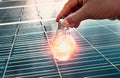 hand holding lightbulb on solar panel concept clean energy in nature Royalty Free Stock Photo