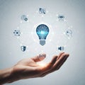 Hand holding lightbulb with technology icons isolated on white background Royalty Free Stock Photo
