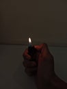 Hand Holding a Lighter with Flame in Low Light Royalty Free Stock Photo