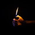 Hand holding lit lighter in the dark Royalty Free Stock Photo