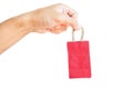 Hand holding little red shopping bag, isolated on white background Royalty Free Stock Photo