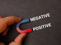 Hand holding magnet with text NEGATIVE POSITIVE Royalty Free Stock Photo