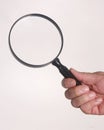 Hand holding a magnifying glass