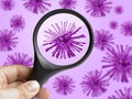 Hand holding magnifying glass focusing on virus bacterium cell