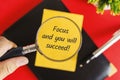 Hand Holding Magnifying Glass Focusing on Yellow Sticky Note with Life Lesson Quote