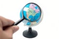 Hand holding magnifying glass over earth globe Royalty Free Stock Photo