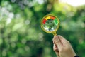 Hand holding a magnifying glass to check the good air quality and clean outdoor air quality safe