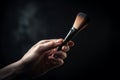 Hand holding makeup brush, cosmetic equipment on neutral gray background in studio, man\'s make up. AI generated Royalty Free Stock Photo