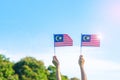 Hand holding Malaysia flag on blue sky background. September Malaysia national day and August Independence day