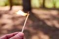 Hand holding a match on fire in the forest Royalty Free Stock Photo